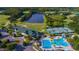 Aerial shot showcases a community clubhouse, pool, tennis courts, and a golf course near a large pond, emphasizing recreational amenities at 10559 Coral Key Ave, Tampa, FL 33647
