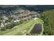 Golf course community aerial view features lush green fairways, a large pond, and residential homes in a desirable neighborhood at 10559 Coral Key Ave, Tampa, FL 33647