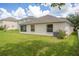 Backyard view featuring lush green grass and partial view of the home's exterior at 10559 Coral Key Ave, Tampa, FL 33647