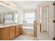 Well-lit main bathroom with double sinks, a separate tub, and a glass-enclosed shower for a luxurious feel at 10559 Coral Key Ave, Tampa, FL 33647