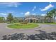 A view of the clubhouse showcasing meticulously landscaped grounds, well-maintained facade, and inviting circular driveway entrance at 10559 Coral Key Ave, Tampa, FL 33647