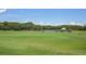 Manicured driving range featuring a lake and mature trees, perfect for practicing your swing at 10559 Coral Key Ave, Tampa, FL 33647