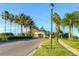 Community entrance view showcasing a well-maintained road leading to a gated entry, enhanced by palm trees and manicured greenery at 10559 Coral Key Ave, Tampa, FL 33647