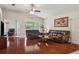 Bright living room with hardwood floors, comfortable leather sofas, and sliding doors to the outside at 10559 Coral Key Ave, Tampa, FL 33647