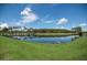 A calm pond with a bridge and palm trees, reflecting the sky and lush green grass of the surrounding golf course at 10559 Coral Key Ave, Tampa, FL 33647