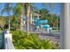 Resort-style pool area featuring a water slide, palm trees, and lounge chairs for relaxation at 10559 Coral Key Ave, Tampa, FL 33647