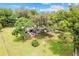 Aerial view of home featuring mature landscaping, backyard patio, circular driveway, and well-maintained lawn at 11317 Fort King Rd, Dade City, FL 33525