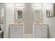 Bathroom featuring dual sinks with white cabinets, decorative mirrors and tile flooring at 11317 Fort King Rd, Dade City, FL 33525