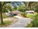 Aerial view of home featuring a circular driveway, fenced yard, well-maintained lawn, and detached outbuilding at 11317 Fort King Rd, Dade City, FL 33525
