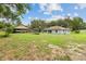 A bright home is situated on a grassy lot with a separate outdoor structure at 11317 Fort King Rd, Dade City, FL 33525