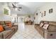 Bright and airy living room showcasing tile flooring, ceiling fan, and comfortable furniture at 11317 Fort King Rd, Dade City, FL 33525