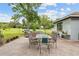 Outdoor patio with a glass dining table, grill, and views of the expansive backyard and landscaping at 11317 Fort King Rd, Dade City, FL 33525