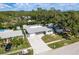 Aerial view showcasing the home's layout, paved driveway, and proximity to surrounding greenery at 1144 Woodbrook Dr, Largo, FL 33770