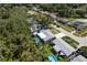 Aerial view of the backyard featuring an in-ground pool surrounded by a green lawn with mature trees at 1144 Woodbrook Dr, Largo, FL 33770