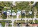 Overhead view shows a neighborhood with mature trees, in-ground pools and single story ranch-style homes at 1144 Woodbrook Dr, Largo, FL 33770