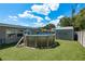 Backyard showcasing the above-ground pool with artificial grass, fenced for privacy, and two sheds at 1144 Woodbrook Dr, Largo, FL 33770