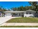 Well-maintained single-story home with a manicured lawn and plenty of natural light beaming through the windows at 1144 Woodbrook Dr, Largo, FL 33770