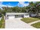 Charming single-story home with a well-manicured lawn and a paved driveway leading to an attached garage at 1144 Woodbrook Dr, Largo, FL 33770