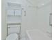 A bright bathroom featuring tiled walls, a bathtub, and a toilet with storage at 1210 Eastloch Ct, Sun City Center, FL 33573