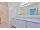 A bathroom featuring white cabinets, a bathtub, and an expansive mirror at 1210 Eastloch Ct, Sun City Center, FL 33573