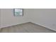 Bright bedroom showcasing durable, gray laminate floors and a sunlit window at 1210 Eastloch Ct, Sun City Center, FL 33573