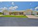Charming single-story villa featuring a well-manicured lawn, stone accents, and attached garage at 1210 Eastloch Ct, Sun City Center, FL 33573