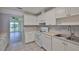 Bright kitchen features white cabinets, appliances, and tile floor at 1210 Eastloch Ct, Sun City Center, FL 33573
