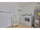A convenient laundry area featuring a utility sink, washer, dryer, and a water heater at 1210 Eastloch Ct, Sun City Center, FL 33573