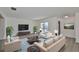 Bright living room with modern decor, plush seating, neutral color scheme, and a large window offering ample natural light at 1210 Eastloch Ct, Sun City Center, FL 33573