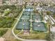 Aerial view of the tennis courts, nestled among trees in a residential community with nearby lake views at 1210 Eastloch Ct, Sun City Center, FL 33573