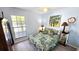 Bright bedroom featuring a floral-patterned bed, a side table with lamp, and natural light at 13 Windrush Bay Dr, Tarpon Springs, FL 34689