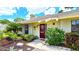 Cozy home exterior with a red front door, well-kept garden, and ample natural light at 13 Windrush Bay Dr, Tarpon Springs, FL 34689