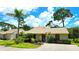 Charming single-story home with a well-manicured lawn and lush landscaping, including a tall palm tree at 13 Windrush Bay Dr, Tarpon Springs, FL 34689