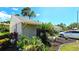 Beautifully landscaped home exterior with lush greenery, mature palms, and an inviting driveway at 13 Windrush Bay Dr, Tarpon Springs, FL 34689