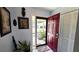 Inviting foyer featuring a red front door, tiled flooring, and decorative wall art at 13 Windrush Bay Dr, Tarpon Springs, FL 34689