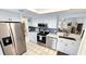 Well-lit kitchen featuring stainless steel appliances, white cabinets, and tile backsplash at 13 Windrush Bay Dr, Tarpon Springs, FL 34689