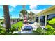 Lovely outdoor patio featuring seating, greenery, a nearby pool, and scenic waterfront views at 13 Windrush Bay Dr, Tarpon Springs, FL 34689