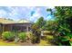 Backyard view of the screened patio area with outdoor seating, surrounded by lush landscaping at 13 Windrush Bay Dr, Tarpon Springs, FL 34689