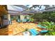Covered outdoor patio featuring stylish furniture, lighting, and access to the garden at 13 Windrush Bay Dr, Tarpon Springs, FL 34689