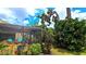 Backyard view highlighting the screened patio with chairs and lush landscaping for a peaceful setting at 13 Windrush Bay Dr, Tarpon Springs, FL 34689
