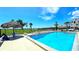 Community swimming pool with clear blue water, tiki hut, and lounge chairs for relaxing by the poolside at 13 Windrush Bay Dr, Tarpon Springs, FL 34689