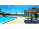Outdoor pool area with lounge chairs, tiki umbrellas and a beautiful view of the open water at 13 Windrush Bay Dr, Tarpon Springs, FL 34689