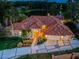 Stunning aerial view of tile roof home with lush landscaping and lake views in a beautiful, private setting at 1303 Forestedge Blvd, Oldsmar, FL 34677