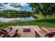 Backyard patio area overlooking lush lawn and community pond at 1303 Forestedge Blvd, Oldsmar, FL 34677