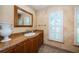 Bathroom featuring granite countertop, wood cabinets, tile flooring, and a window with shutters at 1303 Forestedge Blvd, Oldsmar, FL 34677