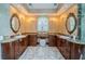 Bathroom featuring dual sinks, granite countertops, a makeup vanity, and marble floors at 1303 Forestedge Blvd, Oldsmar, FL 34677
