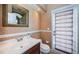 Stylish half bathroom featuring granite countertops, a vessel sink, decorative mirror, and door to exterior at 1303 Forestedge Blvd, Oldsmar, FL 34677