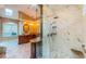 Elegant bathroom featuring a large shower with marble tile and dual vanities with granite countertops at 1303 Forestedge Blvd, Oldsmar, FL 34677
