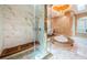 Luxurious primary bathroom featuring a glass enclosed shower, soaking tub, chandelier, and marble tile at 1303 Forestedge Blvd, Oldsmar, FL 34677