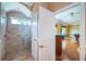 Shower room next to a living room with a pool table on hardwood floor with an entertainment area at 1303 Forestedge Blvd, Oldsmar, FL 34677